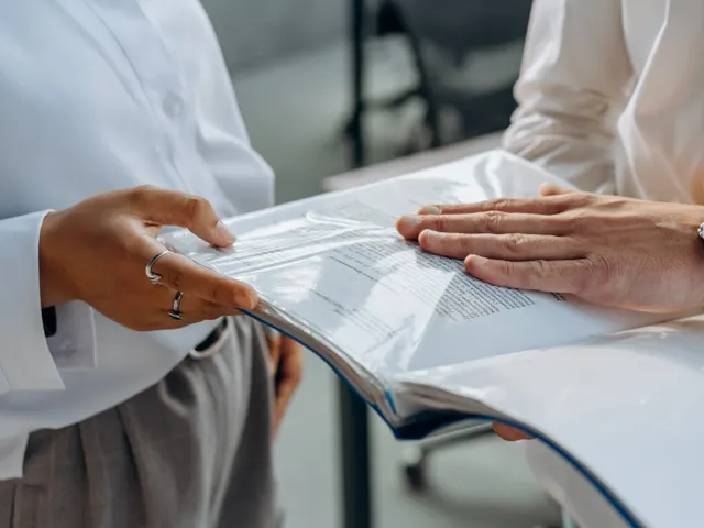 Dos personas revisando documentos de seguimiento